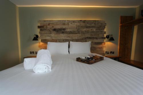 a bedroom with a large white bed with a brick wall at Tyr Winch in Cardiff