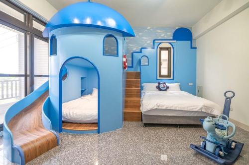 a childs bedroom with a blue play house at Cute ohpa BnB in Luodong
