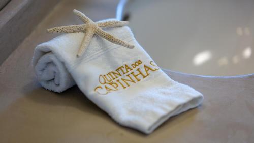 a towel with a starfish on it next to a sink at Quinta dos Capinhas in Porches