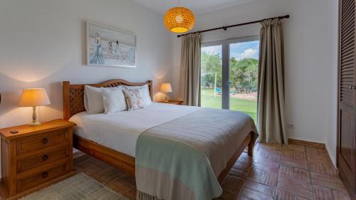 a bedroom with a bed and a large window at Luxury Villa With Pool in Vineyard Near the Beach in Porches