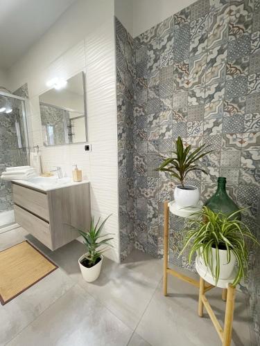 a bathroom with a sink and two potted plants at Casa Lulu in Belpasso