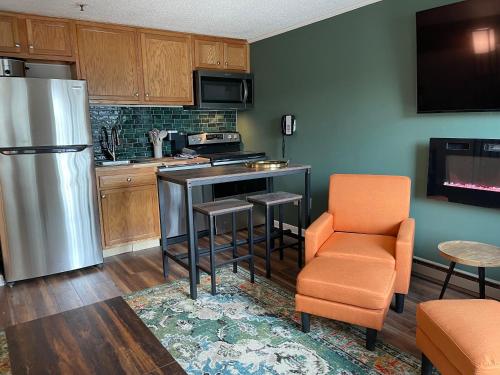 a kitchen with a refrigerator and a table and a chair at Mountain Lodge getaway, ski-in/ski-out, heart of the village in Snowshoe