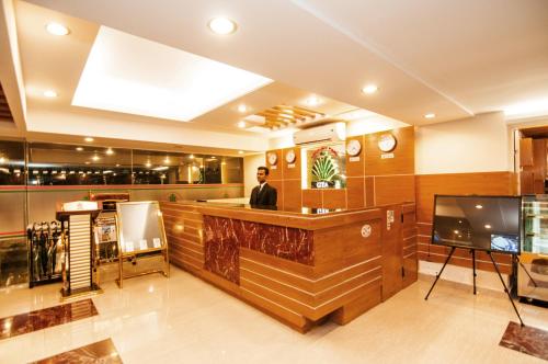 a man standing at a bar in a restaurant at Century Park Residence in Dhaka