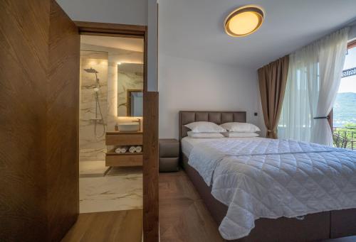a bedroom with a bed and a bathroom with a shower at Apartments Nikčević in Kotor