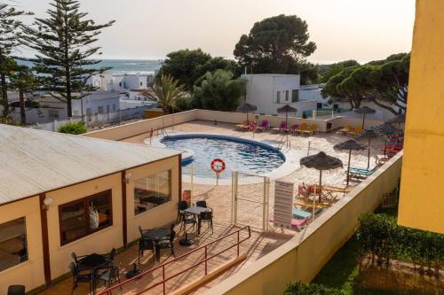 - une vue sur la piscine depuis un bâtiment dans l'établissement Duplex Sereno 6 - Piscina, Garaje, Jardín y Playa, à Los Caños de Meca