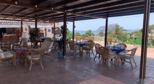 a group of tables and chairs with blue tables and chairs at Hotel Restaurant Baladrar in Benissa