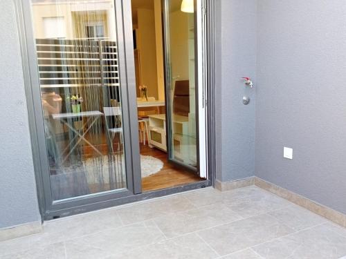 Apartment Paola with free private parking place في سبليت: باب زجاجي يؤدي إلى غرفة مع مطبخ