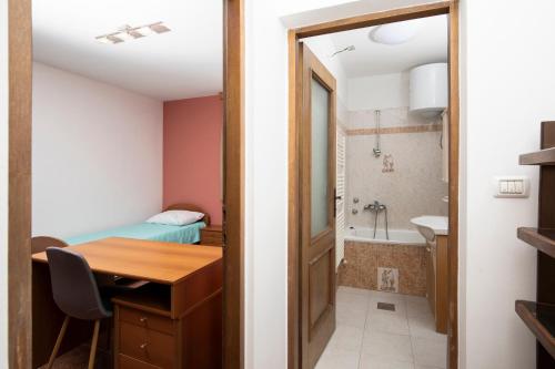Habitación pequeña con escritorio y baño. en Villa Arena - pool table, table tennis, darts & more, en Pula