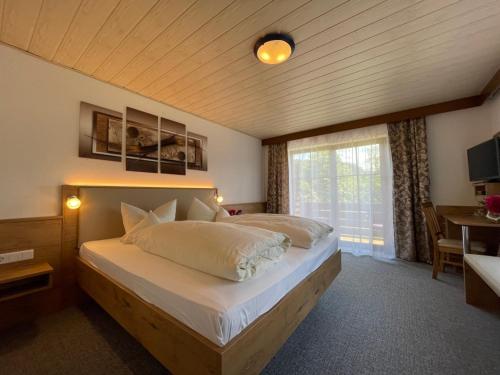 a bedroom with a large bed with a window at Gasthof Pension Fischerstüberl in Blaibach