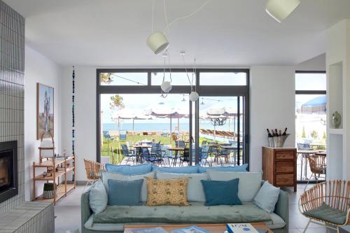 - un salon avec un canapé et une vue sur l'océan dans l'établissement Les Hautes Mers, à L'Ile d'Yeu
