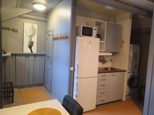 a kitchen with a white refrigerator and a microwave at Mora Life, Åmåsängsgården in Mora