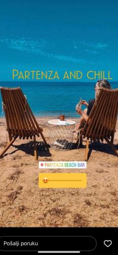 a woman sitting in a chair on the beach at Apartments Lolo in Privlaka