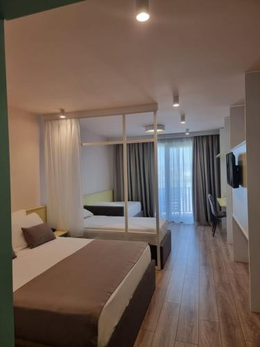 a hotel room with a bed and a television at Amber Hotel Albania in Spille