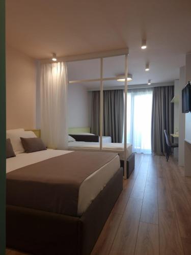 a bedroom with a large bed and a large window at Amber Hotel Albania in Spille