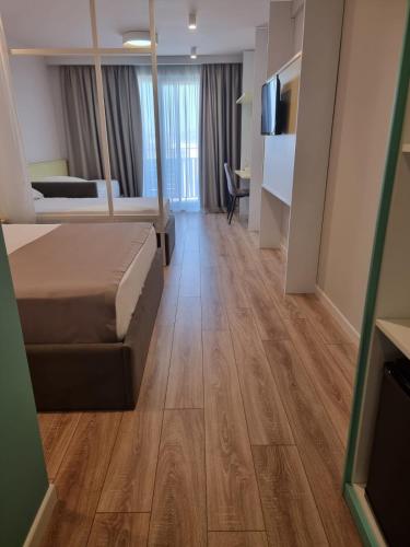 a hotel room with a bed and a television at Amber Hotel Albania in Spille