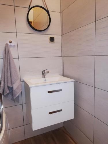 a bathroom with a white sink and a mirror at Babie Lato in Włodarka