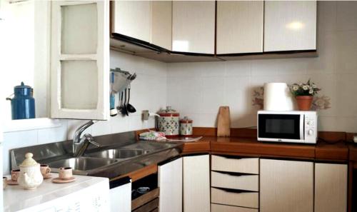 cocina con fregadero y microondas en Ocean front La Maresia Holiday 2 Apartments en Taganana