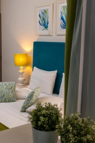a bed with a blue headboard and two plants at Mansion House Parga in Parga