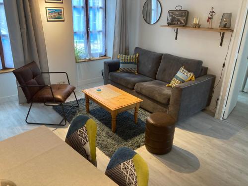 a living room with a couch and a table at Appartement Haute Ville meublé avec cour privative in Granville