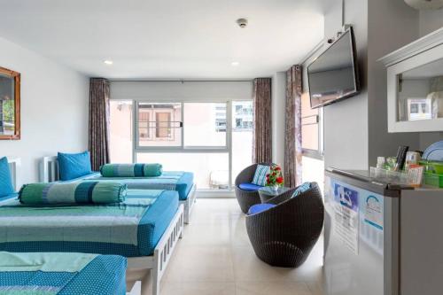 a room with two beds and a flat screen tv at Parvena Hotel Sathorn in Bangkok