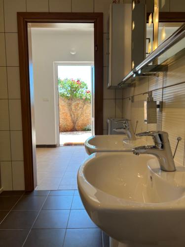 a bathroom with two sinks and a mirror at Apartments Angela in Cesarica