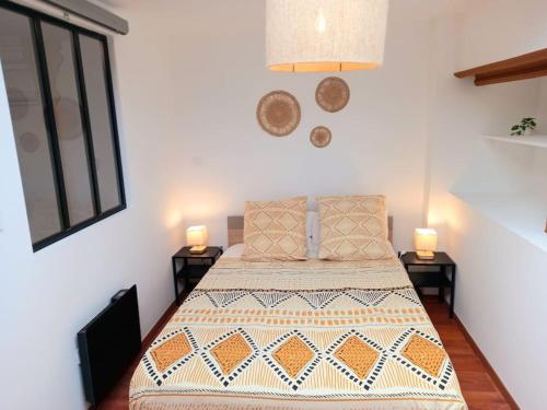 a bedroom with a bed with two lamps on two tables at T5 L'ATELIER in Valence-dʼAgen