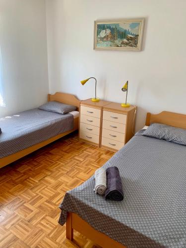 a bedroom with two beds and a dresser with two lamps at APARTMA PANORAMA in Kobarid
