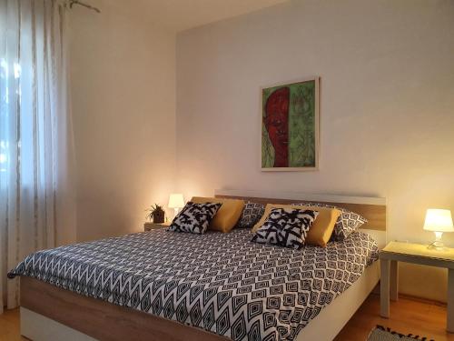 a bedroom with a bed with pillows on it at Apartments Dora in Crikvenica