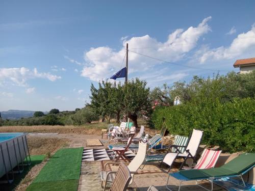 a group of lawn chairs sitting next to a pool at Bed&Breakfast Giardino Agritourist in Controguerra