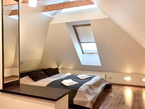 a attic bedroom with a bed and a mirror at Neonele in Palanga