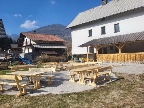 a group of picnic tables in front of a building at Hostel pr Tanovmu Jozlnu in Mojstrana