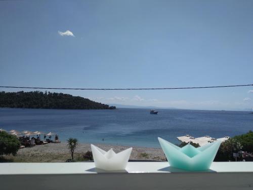 a view of a beach with two white paper flowers at Anastasia Studios & Apartments in Panormos Skopelos