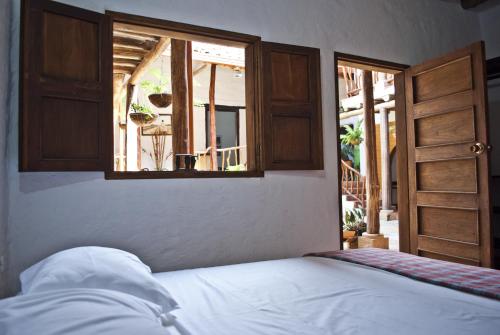 a bedroom with a bed and an open window at Casa Aparicio Lopez in Barichara