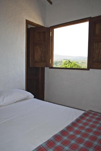 a bedroom with a white bed and a window at Casa Aparicio Lopez in Barichara