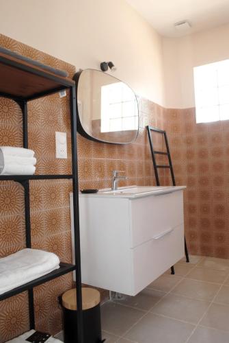 La salle de bains est pourvue d'un lavabo et d'un miroir. dans l'établissement Maison 6 personnes - grand jardin arboré, à Noyers-sur-Cher