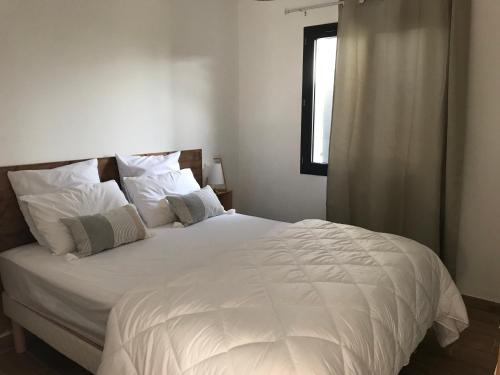 a bed with white sheets and pillows in a bedroom at Gite au coeur du pays Cathare in Verzeille