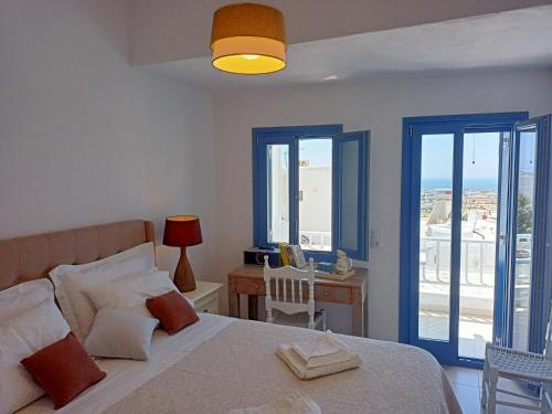 a bedroom with a bed and a desk with a window at Amphitrite's Haven - Cycladic House in Marpissa, Paros in Márpissa