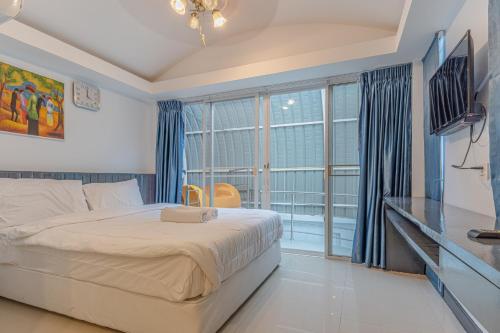 ein Schlafzimmer mit einem Bett und einem großen Fenster in der Unterkunft Mew villa 2 pattaya in Pattaya South