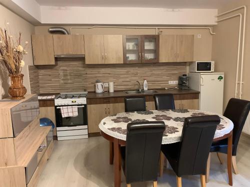 a kitchen with a table and chairs in a kitchen at Malom Vendégház in Szarvas