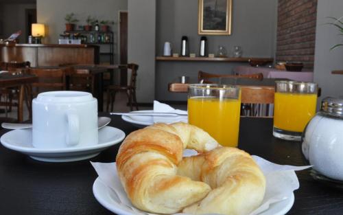 een tafel met croissants en jus d'orange bij Hotel Patagonia Norte in Las Grutas