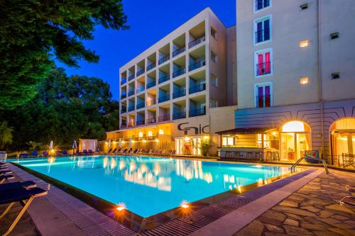 a swimming pool in front of a hotel at night at Corfu Hellinis Hotel in Corfu Town