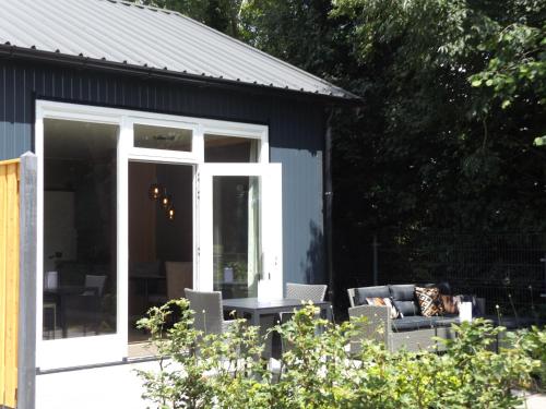 a screened in porch with a couch and a table at Het Broekeroord in Wezep