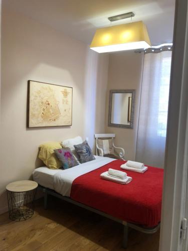 une chambre avec un lit avec une couverture rouge dans l'établissement Appartement en plein cœur de vieille Nice, à Nice