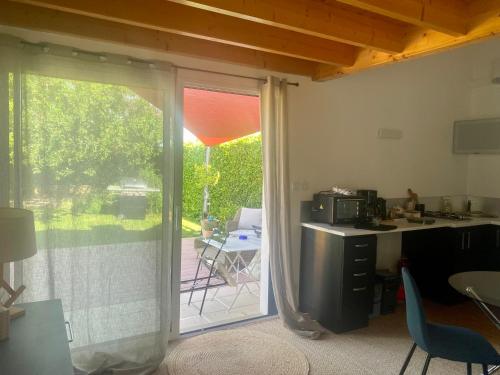 d'une cuisine avec une porte coulissante en verre s'ouvrant sur une terrasse. dans l'établissement La Petite Chaunière, à Saint-Fulgent