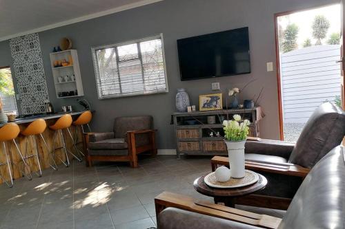 a living room with a couch and a tv at Greystoke - Furnished, self service apartment. in Springs