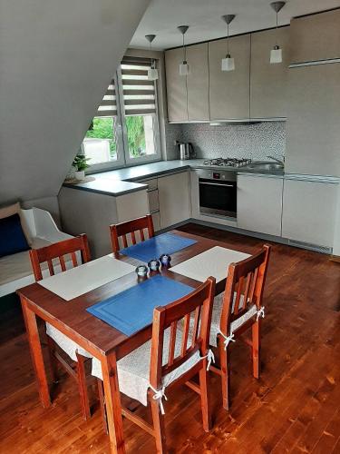 une cuisine avec une table en bois et des chaises ainsi qu'un astérisque dans l'établissement Apartament Gdańsk'a, à Nowy Dwór Gdański