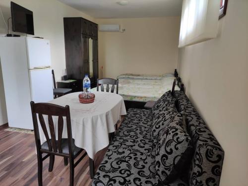 een kamer met een tafel en stoelen en een koelkast bij Studio Oasis-shabla in Shabla