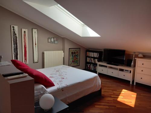 a bedroom with a large bed and a television at La mansarda di Mi&Lo junior suite in Bollate