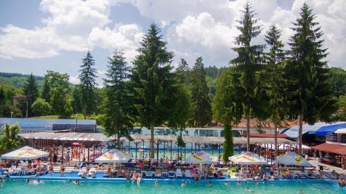 a group of people in the water at a swimming pool at Apartament Iulia in Geoagiu Băi