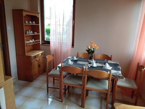 a dining room with a table and chairs and a window at Valéria Vendégház in Balatonföldvár